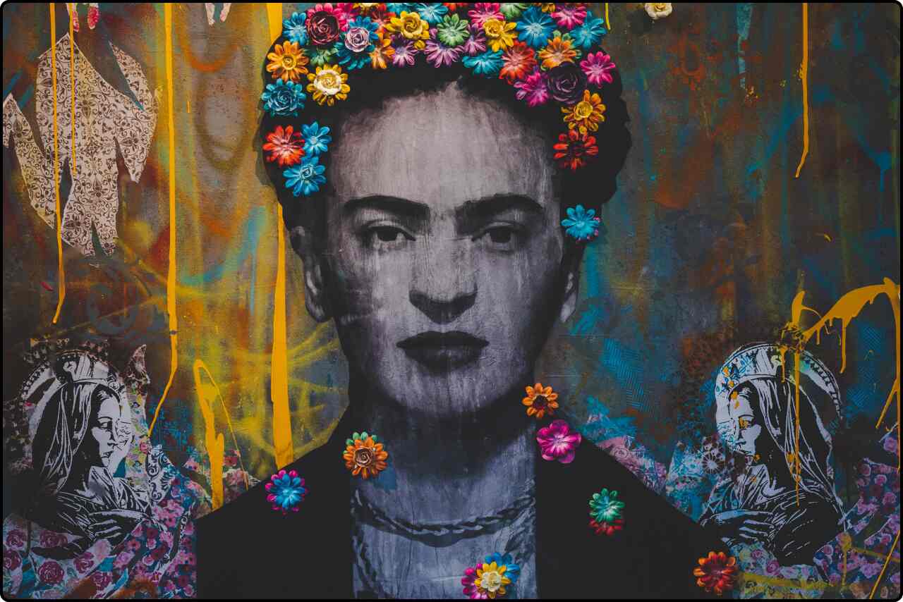 A colorful graffiti wall featuring a vibrant portrait of Frida Kahlo.